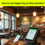 Customer using Apple Pay at Olive Garden checkout in 2025 with iPhone and contactless payment terminal